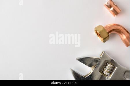 Plumbing conceptual background with tools and metal pipes on white background. Top view. Horizontal composition. Stock Photo