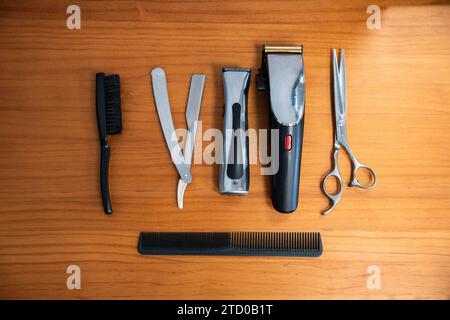 Directly above shot of various barber tools arranged on wooden table in shop Stock Photo