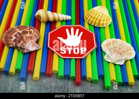 Plastic straws with stop sign, shells and snail shells from the sea, ban on plastic, marine littering Stock Photo