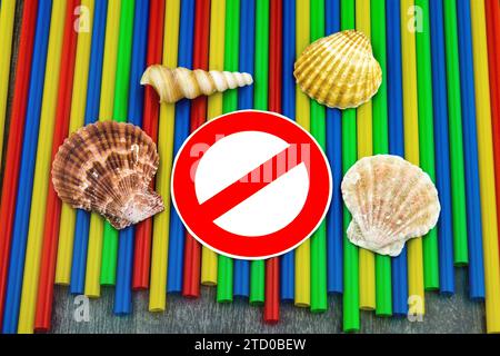 Plastic straws with prohibition sign, shells and snail shells from the sea, ban on plastic, marine littering Stock Photo