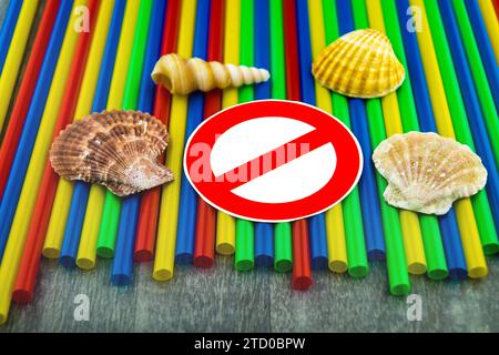 Plastic straws with prohibition sign, shells and snail shells from the sea, ban on plastic, marine littering Stock Photo