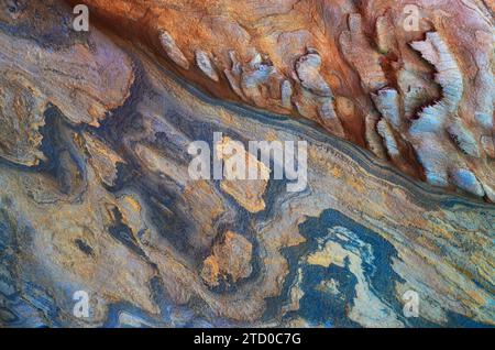 A close-up of a naturally vibrant rock formation displaying a beautiful blend of colors and textures. Stock Photo