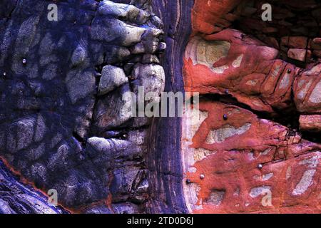 A high-resolution image capturing the richly colored geological layers and textures of rocks along the Occidental Coast of Asturias in Spain. Stock Photo