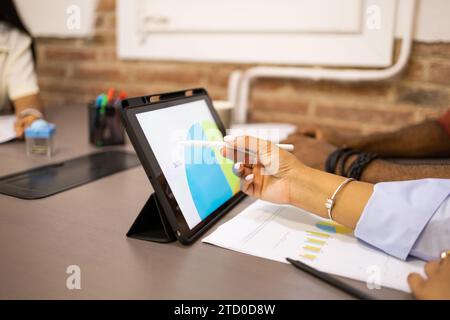 Crop hands of anonymous of colleagues discussing business strategy over digital tablet in meeting at desk in creative office Stock Photo