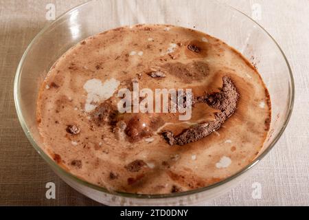 High angle Closeup of a glass bowl filled with milk and powdered chocolate placed on table Stock Photo