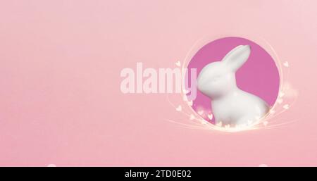 Curious easter bunny or rabbit peeking through a hole, holiday in spring, greeting card with little hearts Stock Photo