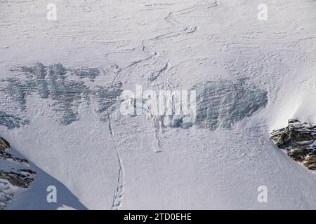 Aerial view of anonymous tourist snowboarding on majestic snow covered mountain slope during vacation in Zermatt, Switzerland on sunny day Stock Photo