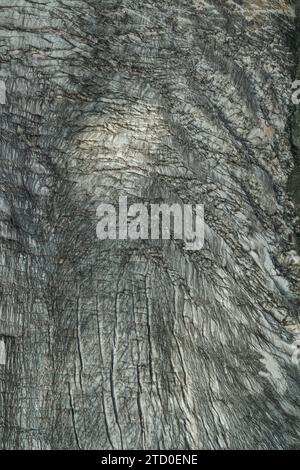 Full frame closeup shot of snow covered rocky mountain with textured pattern during winter at Swiss Alps Stock Photo