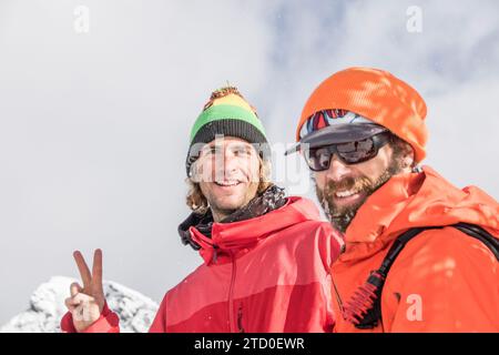 Portrait of happy Caucasian male travelers in warm clothes smiling and looking at camera while enjoying winter vacation in Canada Stock Photo