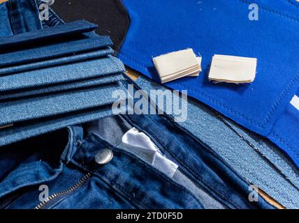 A close-up view of various denim textiles and fabric patches laid out for garment repairs or creative sewing endeavors. Stock Photo