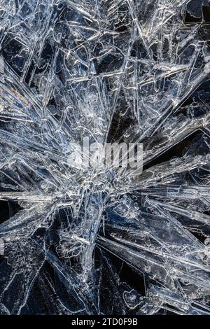A close-up of complex ice crystals forming an abstract design against a contrasting dark background. Stock Photo