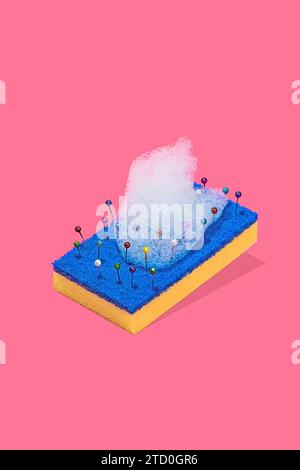 A creative representation of a blue and yellow scouring pad with colorful pins and bubbles of foam against a pink background Stock Photo