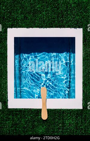 Overhead top view shot of diving platform made with wooden stick over rippled water in swimming pool isolated on green artificial background Stock Photo