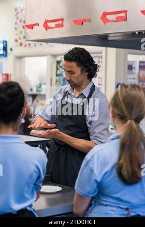 Students studying food technology for GCSE and working preparing food in the kitchen. Stock Photo