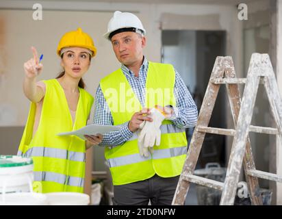 Woman and man repairers talking about documentation Stock Photo