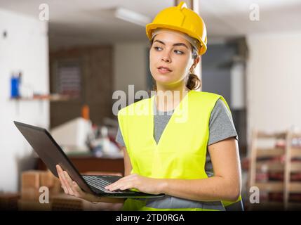 Female civil engineer using laptop at construction site indoors Stock Photo
