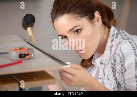 woman installing new wood floor at house Stock Photo