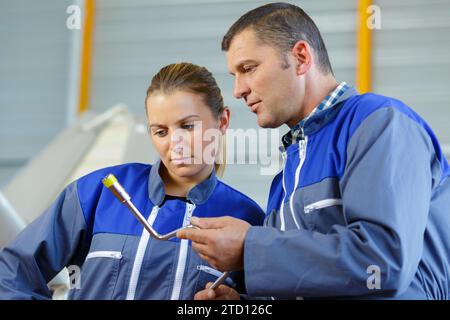 team of technicians looking at mechanical object Stock Photo