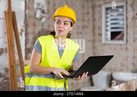 Young female architect using laptop at construction site Stock Photo
