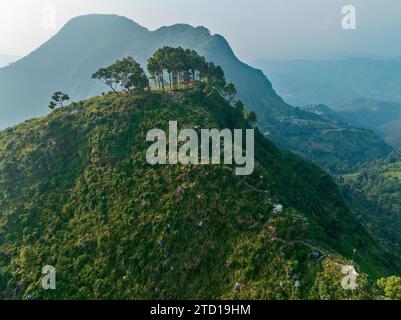 Aerial view of the hill of Thani mai temple, close to Bandipur, Nepal. View of the hill in backlight with the silhouettes of trees and temples Stock Photo