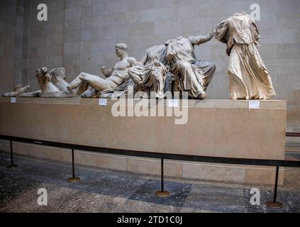 London, UK  15 Dec 2023 Visitors looking at the sculptures. The Elgin Marbles in the Parthenon Galleries at the British Museum. The Ancient Greek sculptures were removed from Greece and shipped to Britain between 1801-1812 by agents of Thomas Bruce, the 7th Earl of Elgin. Greece has been asking that the sculptures are returned but the British Government said that a loan may be possible. Lord Frost recently said he favoured a return of the sculptures to Greece. Rishi Sunal cancelled a recent meeting with Kyriakos Mitsotakis, Greek prime Minister. Stock Photo