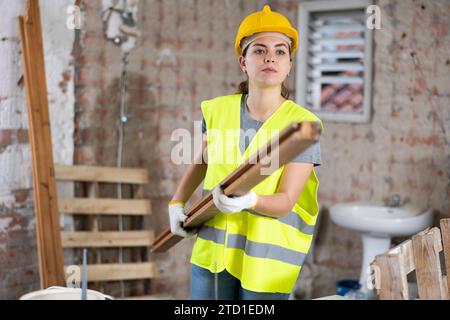 Female carrying wooden panel on construction site Stock Photo