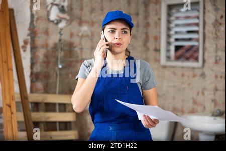 Female talking on phone at building site Stock Photo
