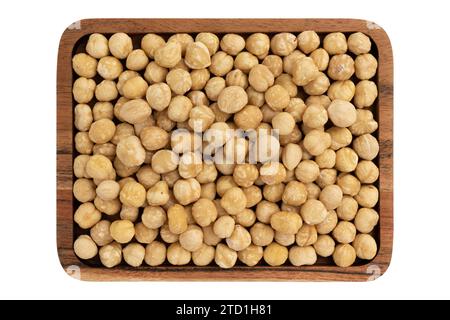 top view of roasted peeled hazelnuts in wooden plate isolated on white background, top view, healthy food concept Stock Photo