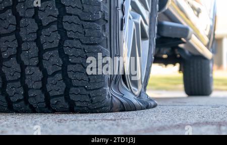 Flat tire on truck on cement, close up, low angle view Stock Photo