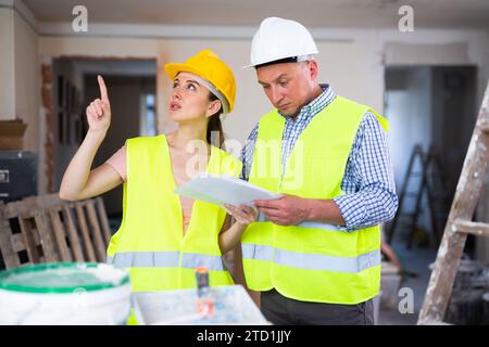 Woman and man repairers talking about documentation Stock Photo
