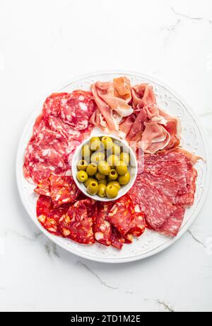 Assortment of Italian and Spanish sliced meat appetizer, prosciutto, salami and ham, with olives Stock Photo