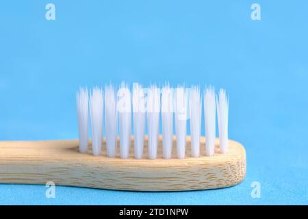 Eco friendly wooden toothbrush with white bristle on blue background Stock Photo