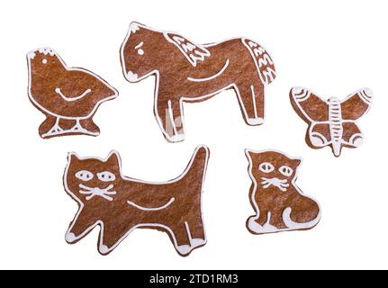 Baked gingerbread cookies in cat, horse, bird or butterfly shape isolated on white background. Set of cute edible animal toys decorated by sweet icing. Stock Photo