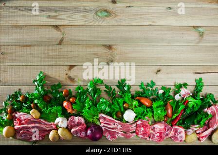 Raw mutton and vegetables assortment on natural wooden background Stock Photo