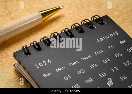 January 2024 Black spiral desktop calendar on red textile Stock Photo ...