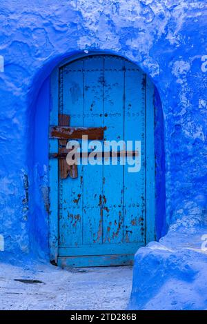 Old door painted blue, in a narrow street in the medina of Chefchaouen, Morocco Stock Photo