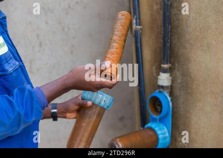 Black blue collar worker shows dirty rusty filters that need to be changed. Stock Photo