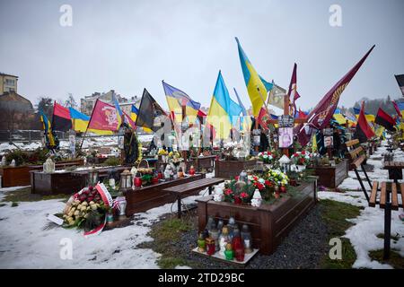 Lviv, Ukraine. 15 December, 2023. Flags, banners and photos decorate soldiers graves at the Lychakiv Military Cemetery, December 15, 2023 in Lviv, Ukraine. Credit: Ukraine Presidency/Ukrainian Presidential Press Office/Alamy Live News Stock Photo