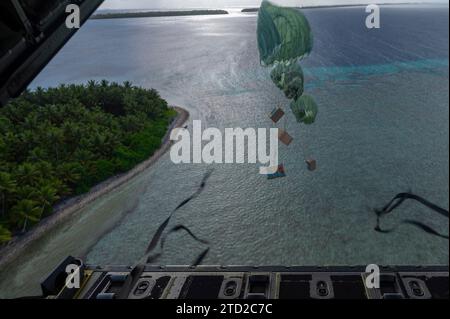 Oneop, Mortlock Islands, Federated States of Micronesia. 03 December, 2023. Humanitarian bundles parachute to a lagoon from a U.S. Air Force C-130J Super Hercules aircraft assigned to the 36th Expeditionary Airlift Squadron, during Operation Christmas Drop, December 3, 2023 in Oneop, Mortlock Islands, Micronesia. Operation Christmas Drop is the oldest humanitarian and disaster relief mission delivering 71,000 pounds of food, gifts, and supplies to assist remote island communities in the South Pacific.  Credit: SrA Brooklyn Golightly/US Airforce Photo/Alamy Live News Stock Photo