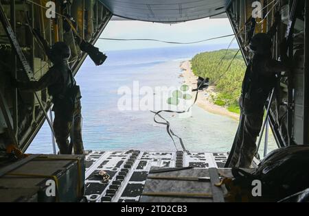Nama, Upper Mortlock Islands, Federated States of Micronesia. 04 December, 2023. Humanitarian bundles parachute to a lagoon from a U.S. Air Force C-130J Super Hercules aircraft assigned to the 36th Expeditionary Airlift Squadron, during Operation Christmas Drop, December 4, 2023 in Nama, Eastern Islands, Micronesia. Operation Christmas Drop is the oldest humanitarian and disaster relief mission delivering 71,000 pounds of food, gifts, and supplies to assist remote island communities in the South Pacific.  Credit: SrA Allison Martin/US Airforce Photo/Alamy Live News Stock Photo