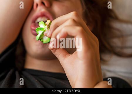 teenage girl lying down eating multi-colored marmeshow Stock Photo