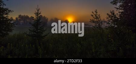 A misty sunrise over a nothern Wisconsin hayfield. Stock Photo