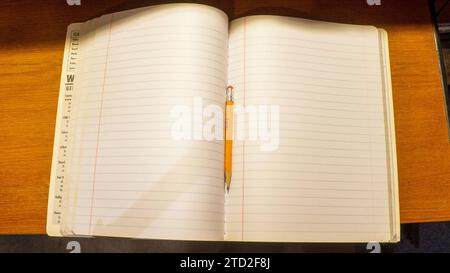 A High Angle View of a Pencil and a Notebook Stock Photo