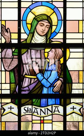 Saint Anne (the Mother of the Virgin Mary). A stained-glass window in Église Saint-Laurent (St Lawrence's Church), Strassen, Luxembourg. Stock Photo