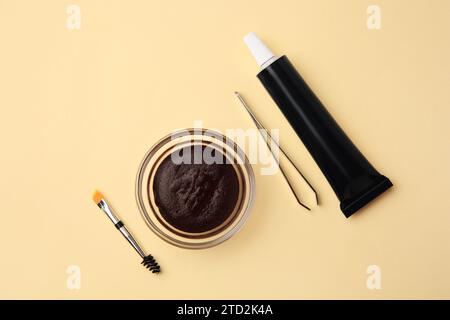 Flat lay composition with eyebrow henna and tools on beige background Stock Photo
