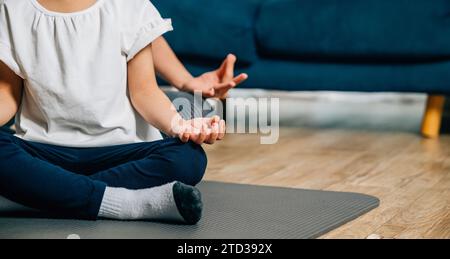 A mother and her daughter find serenity in family yoga sitting in lotus ...