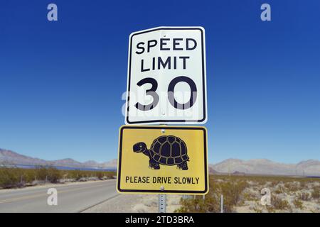 Road sign in a desert area indicating a speed limit of 30 mph warning for desert tortoises potentially crossing the road. Stock Photo