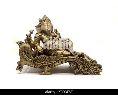 antique golden statue of elephant headed god lord ganesh sitting on a peacock throne isolated in a white background Stock Photo