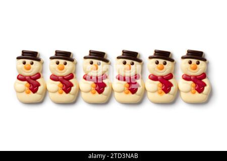 Happy white chocolate snowmen in a row on white background close up Stock Photo