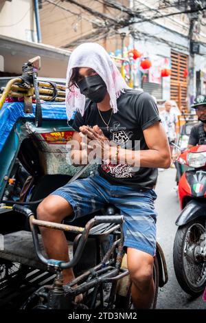 A tuk tuk or trike driver makes his way through the busy streets of the Binondo district of Manila, The Philippines. Stock Photo